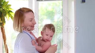 生命中最美好的时刻，一位慈爱快乐的年轻母亲拥抱着一个哺乳的儿子，拥抱在一条蓝色的毯子上，上面有花，拥抱在白色的毯子上